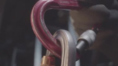 İşçi, yarı karanlık odada metal parçalarıyla yay şaklatmasını birbirine bağlıyor. Çalışan fabrika atölyesinde çalışan güvenlik ekipmanları kullanıyor