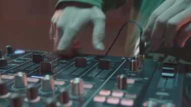Disk jokeyi, disko partisinde konsol seviyesinde müzik yapıyor. Müzisyen partide mikserle elektronik müzik çalar