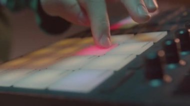 DJ muslukları kontrol panelinin üzerinde parlayan plastik düğmeler gece kulübü kapanışında lazer gösterisi yapıyor. Operatör partide ışık renklerini karıştırır