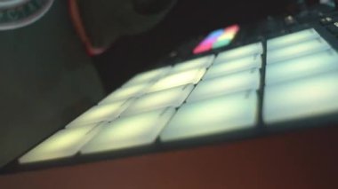 Adam lazer şovu kapanışında sahne feneri rengini değiştirmek için farklı tuşlara basıyor. Gece kulübündeki ışıklı noktaların parlayan konsolu