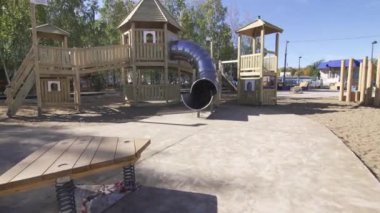 Çok renkli ekipmanlı boş oyun parkı çocukları bekliyor. Güneşli bir günde halka açık parkta merdivenli ve slaytlı çocuklar için oyun alanı