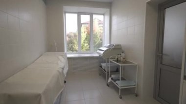 Enstrümanlar için kuvars sterilizatörlü iyi ışıklandırılmış hastane koğuşu. Özel sağlık ünitesi hasta yatağı ve sağlık sehpası ile tamamlandı.