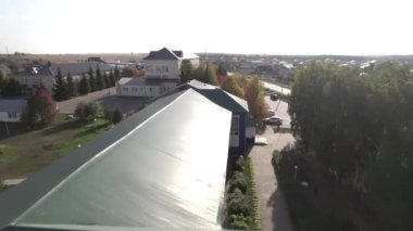 Şehrin sokaklarında tahta çatıları olan modern kulübeler. Hava perspektifi, banliyö mahallelerinin yerleşim hayatı hakkında içgörü sunar