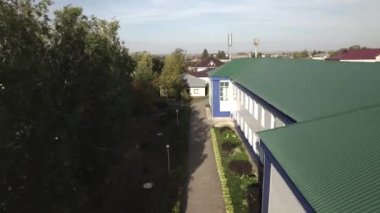 Çevresi yeşilliklerle çevrili küçük kasaba hava manzaralı. Yüksek çözünürlüklü hava görüntüleriyle çekilen yaz kasabasının sakin atmosferi