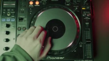 ALMATY, KAZAKHSTAN - 21 FEBRUARY 2024: DJ gece kulübü partisinde pikapta elektirikli müzik çalıyor. Müzisyen, konukları dans setiyle eğlendirir. Gece hayatı eğlencesi