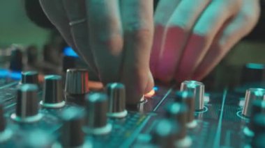 ALMATY, KAZAKHSTAN - 21 Şubat 2024: DJ gece kulübünün kapanışında düğmeleri ses konsoluna çeviriyor. Ev sahibi, gece partisinde modern ekipmanlarla dans müziği çalıyor. Elektrik ses seti