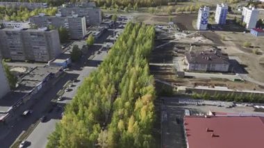 Modern otoyol ve yoğun bahçe ile kesişen çok katlı binalar bloğu. Büyük şehir hava manzarasında yeni geliştirilmiş yeşil alanlar