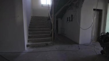 Dinlenme merkezi koridorunda merdiven var. Tatil köyü inşaatının sürecinde beton duvarlar boyunca kablolar çekilir