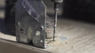 İşçi, açıyı beton kirişe bağlamak için pervane ve koç cıvatası kullanır. Atölyede inşaat faaliyeti dinamik bir şekilde gelişiyor