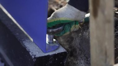 İnşaatçı titizlikle ingiliz anahtarıyla beton plastik yapıya sürgüler. Şehir konut bölgesine yerleştirilen dinlenme alanının elden geçirilmesi