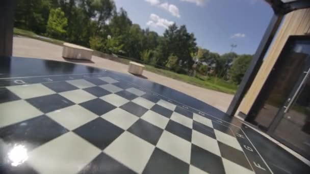 市立公園のテラスに印刷されたチェスボード付きの広々としたテーブル 特別なスペースはレジャー活動のための快適な機会を提供します — ストック動画