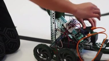 İnsan geliştirici test sırasında robottaki kabloları kontrol eder. Mühendis, düzgün bir güvenlik ve işlevsellik sağlamak için bağlantı noktasını inceliyor.