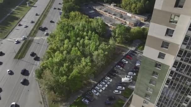 高層ビルの住民のための広々とした駐車場 活気あふれる道路に近い緑の木を有する近代的な住宅街 — ストック動画