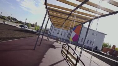 İlkokulun bölgesinde sallanan bankları olan çocuk parkı. Anaokulunda çocukları eğlendirmek için salıncaklar.