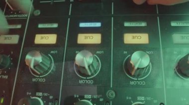 Profesyonel DJ, ekolayzır düğmesini atmosferi geliştirmek için ayarlar. Deneyimli müzisyen düğmesine basar ve hafif ayarlama yapar