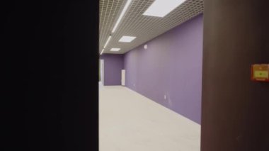 LED lambalarla aydınlatılmış parlak renkli duvarları olan genişletilmiş ilkokul koridoru. Çağdaş özel ilkokul