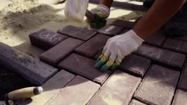 Elinde çekiçle usta bir işçinin yürüttüğü patika. Çevrede devam eden peyzaj çalışmalarına aktif olarak katılan profesyoneller