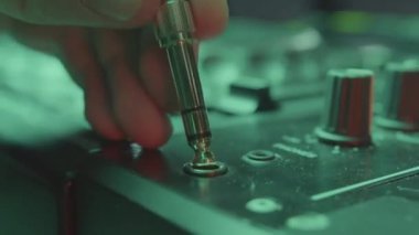 DJ uygun kabloyu seçer ve karıştırıcı girdisine bağlanır. Profesyonel müzisyen kabloyu kullanıma hazır modern miksere bağlıyor