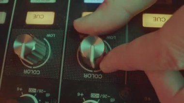 DJ ışıklandırmayı müziğin ruh haline uydurmak için renk ayarları kullanır. İşçi, dinamik görsel görüntü yaratmak ve müziğin zevkini artırmak için düğmeyi çevirir