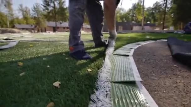 Seorang Pekerja Dalam Sarung Tangan Menginstal Permukaan Lapangan Sepak Bola — Stok Video