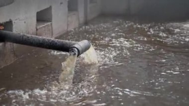 Tortu tankına atık su kanalizasyon borusundan dökülüyor. Tortu ve tedavi için su dolu tedavi tankları
