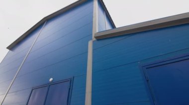 Mavi sanayi binası, üretim tesisi alanı alçak açılı. Üretim tesisinin minimalist mimarisi. Renkli atölye ön cephesi