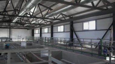 İyi aydınlatılmış pencereli atölyede beton bölümlü sıvı tanklar. Boş atık su tortu havzaları. Operasyon içeriden başlatılacak