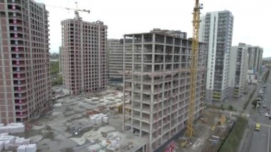 Mühendisler binaların güvenliğini sağlamak için teftiş yapıyorlar. Binaların tasarımları tamamlanmamış durumdaki modern özellikleri içerir.