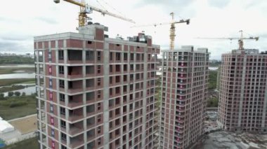 Çelik iskeletler, gelecekteki binaların yapılarını oluşturan zeminden yükselir. Yükselen yapılar kentin ilerlemesini ve gelişimini sembolize ediyor