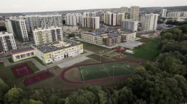 Çok katlı binaların olduğu yerleşim yeri manzarası. Modern tasarımla çevrili spor stadyumu konut binalarıyla çevrili.