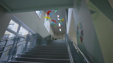 Canlı kağıt parçalarından yapılmış küçük kuşlar tavandan sarkıyor. Merdivenler dikkatlice hazırlanmış kağıt kuşlarla süslenmiş.