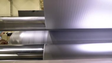 Atölye kapanışında üretim hattının kurutma bölümü üzerine uzun bir sayfa kağıt. Fabrikadaki beyaz doku sarma makineleri