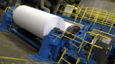 Atölyedeki üretim hattında dönen davulla kağıt rulo yapmak. Kağıt üretim tesisinde selüloz ürünü değirmen makinesiyle kaplamak