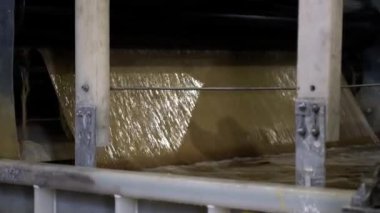 Üretim atölyesindeki tankın içine sıvı hamuru dökülüyor. Modern ekipmanlarla kağıt yapmak için selüloz işleme. Fabrika teknolojisi