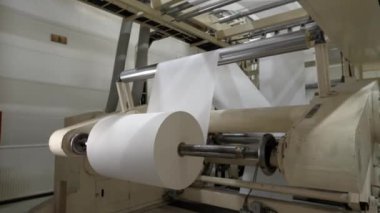 Fabrika atölyesinde metal rulo üretim hattı tarafından sarılmış kağıt levha. Makine aletleri kağıt fabrikasında çalışıyor. Üretim teknolojisi