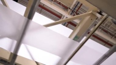 Fabrika atölyesinde peçete şeritlerini makinede kurutmak. Kağıt fabrikasındaki ürünlerle çalışan ekipman