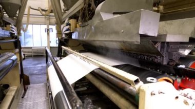 Atölyede ıslak hamuru sıcak rulo makineyle kurutmak. Kağıt şeridi kağıt fabrikasındaki kurutma malzemeleriyle işlenmiş.