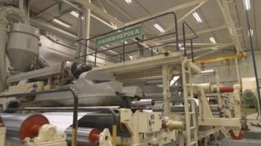 ALMATY, KAZAKHSTAN - 12 Temmuz 2024: ALMATY, KENYA - 12 Temmuz 2024: Parlak metal silindirler fabrika atölyesinde dönüyor. Fabrikadaki kağıt üretimi için güçlü otomatik ekipman