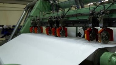 Kağıt levha fabrika atölyesindeki metal silindirler arasında hareket etmiş. Kağıt fabrikasındaki basın makinesinde doku materyali. Endüstriyel teknoloji