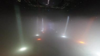 ALMATY, KAZAKHSTAN - 21 Şubat 2024: Profesyonel DJ sahnenin ortasında duran dijital oyuncuda çalışıyor. Konser alanı atmosfer için güçlü spot ışıklarıyla aydınlandı