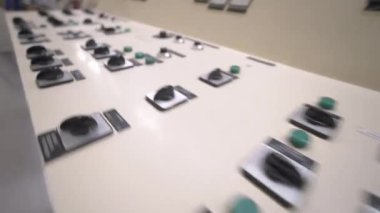 ALMATY, KAZAKHSTAN - 12 Temmuz 2024: kağıt üretim hattının yakınında çeşitli düğmeleri ve kolları olan kontrol paneli. Kağıt endüstrisinde bilgisayar teknolojisi. Fabrikanın içi.