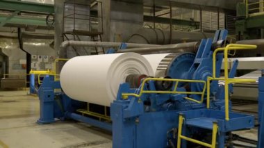 Fabrika üretiminde dönen davul ve silindirlerle kağıt rulo oluşturuyorlar. Kağıt fabrikasındaki doku ürünlerini değirmen makinesine sarmak