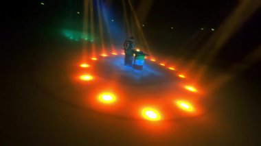 ALMATY, KAZAKHSTAN - 21 Şubat 2024: Müzisyen projektörlerin merkez bölgesinde olduğu için tüm dikkatleri üzerine çekiyor. Adam coşkulu bir şekilde masanın yanında dans ediyor.