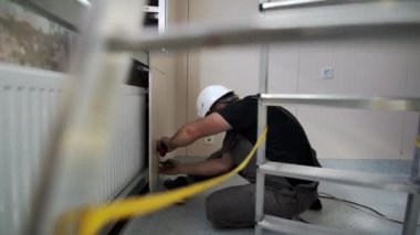 ALMATY, KAZAKHSTAN - 15 Mart 2024: Profesyonel inşaat işçisi vidaları yonga paneline sokuyor. İnsan oluşturucu, sıkıca eklendiğinden emin olmak için yonga tahtasının hizalamasını denetler