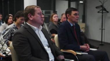 ALMATY, KAZAKHSTAN - 22 HAZİRAN 2024: Açık gömlekli adam iş toplantısında sunucuyla materyal tartışıyor. Konuşmacı dinleyicilerin son yansıması kavramı