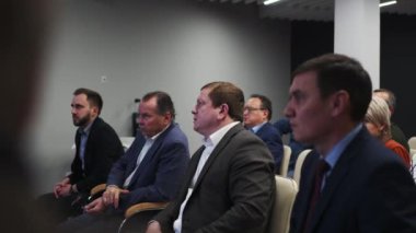 ALMATY, KAZAKHSTAN - 22 HAZİRAN 2024: Gruptan çok sayıda erkek toplantıda sorun tartışmasına aktif olarak katılıyor. Takım elbiseli konsantre insanlar ekranı işaret etmek için ellerini kaldırsın.