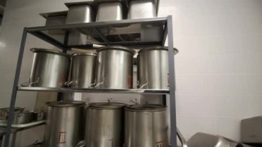 Umumi kantindeki metal raflarda yemek hazırlamak için devasa çelik tavalar. Kafeteryada paslanmaz malzemelerden mutfak gereçleri yapmak. Mutfak malzemeleri.