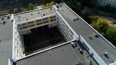 Parlak yüzlü ve şehir merkezinde iç bahçesi olan modern okul binası. Konut bloğundaki öğrenciler için şehir mimarisi. Düz çatılı kampüs