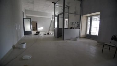 Elektrikçiler bekçi kulübesinde elektrik ağıyla çalışırlar. İnşaatçılar, işletme merkezi koridoruna santral onarım onarımı kuruyor