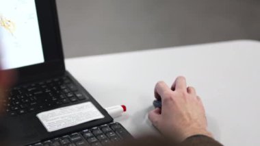 Çalışan, ofiste dizüstü bilgisayarda çalışan fareyi tıklatıyor. Erkek işçi şirket işyerinde dizüstü bilgisayar kullanır. İş teknolojisi.